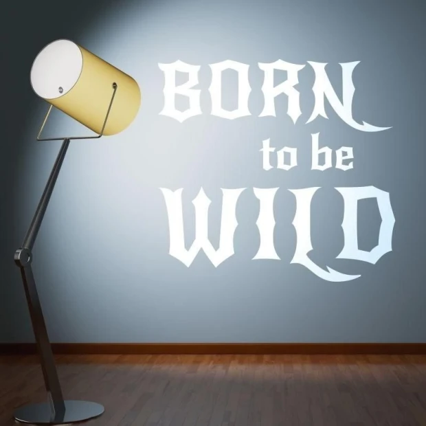 Szablon malarski z napisem born to be wild zaprezentowany w przykładowej białej kolorystyce na ścianie