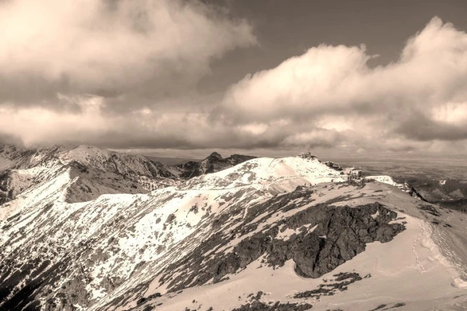 Fototapeta na ścianę Tatry schronisko na szczycie FP 1402 - Wzór graficzny. Góry pokryte śniegiem, chmury w tle, schronisko