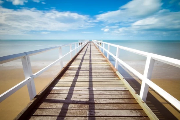 Fototapeta na ścianę z nadrukiem drewnianego pomostu z białymi barierkami prowadzącego w głąb morza