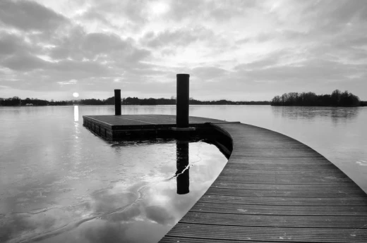Fototapeta na ścianę z czarno-białym nadrukiem drewnianego molo na jeziorze o zachodzie słońca