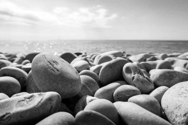 Fototapeta na ścianę z czarno-białym nadrukiem gładkich kamieni na plaży nad morzem