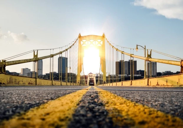 Fototapeta na ścianę most Golden Gate FP 2128 - Wzór graficzny. Most z żółtymi elementami, w tle miasto i słońce