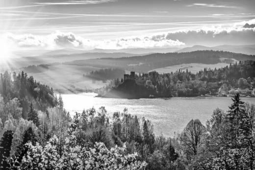 Czarno-biała fototapeta z nadrukiem zamku nad jeziorem o poranku, przedstawiona jako wzór na białym tle