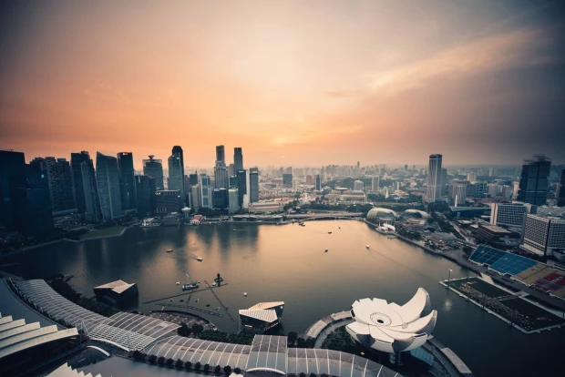 Fototapeta z nadrukiem panoramy Singapuru z wieżowcami i zatoką o zachodzie słońca, przedstawiona jako wzór