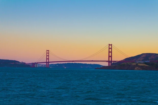 Fototapeta na ścianę z nadrukiem mostu Golden Gate w San Francisco o zachodzie słońca na tle nieba i wody