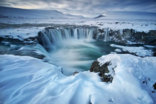 Fototapeta z nadrukiem ośnieżonego wodospadu Godafoss w zimowym krajobrazie Islandii