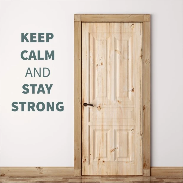 Szablon malarski z sentencją Keep calm and stay strong w przykładowej szarej kolorystyce na ścianie obok drzwi