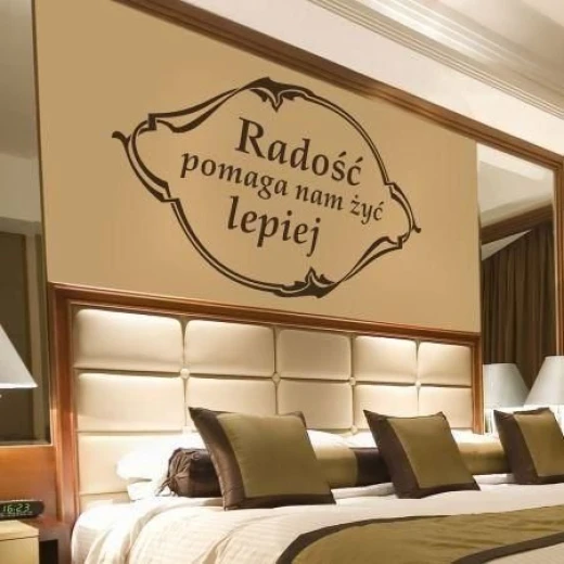 Naklejka na ścianę z napisem Radość pomaga nam żyć lepiej w ozdobnej ramce, w przykładowym brązowym kolorze