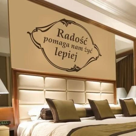 Stylowa naklejka z sentencją Radość pomaga nam żyć lepiej w eleganckiej sypialni, dodająca ciepła i 