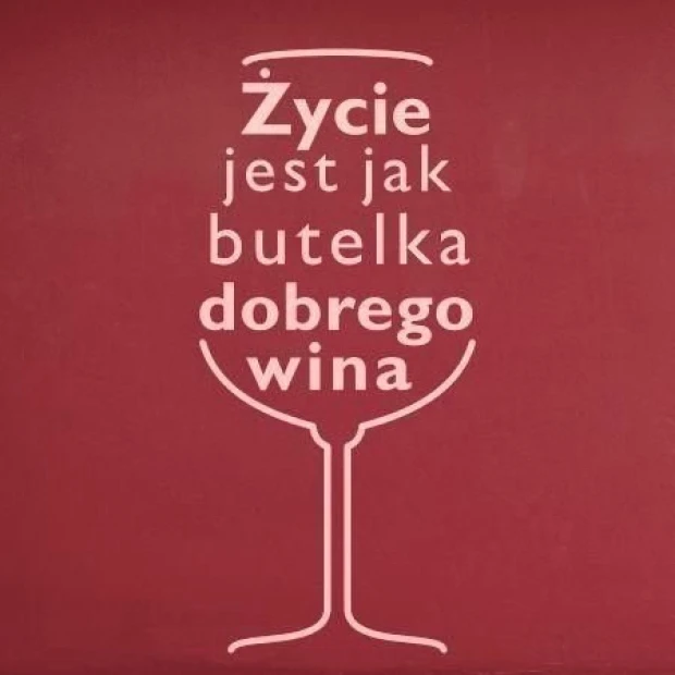 Naklejka ścienna z cytatem o winie wpisanym w kształt kieliszka, w przykładowym jasnoróżowym kolorze