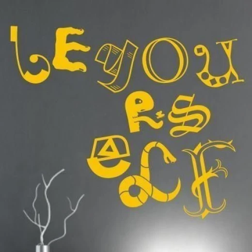 Naklejka na ścianę z napisem BE YOURSELF z ozdobnych liter, w przykładowym żółtym kolorze