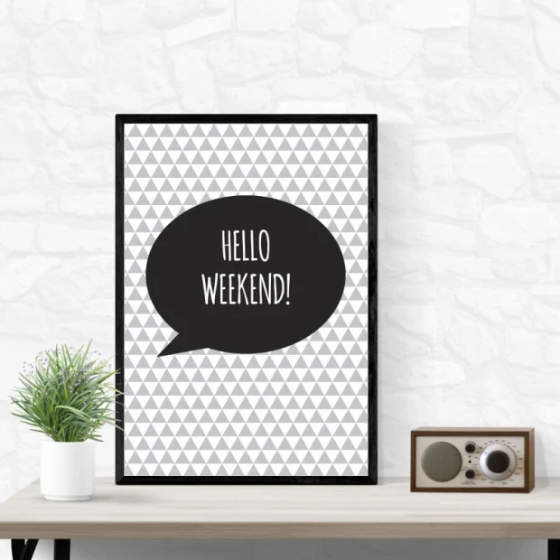 Plakat w czarnej ramie z napisem Hello weekend w dymku na tle szarych trójkątów zaprezentowany we wnętrzu