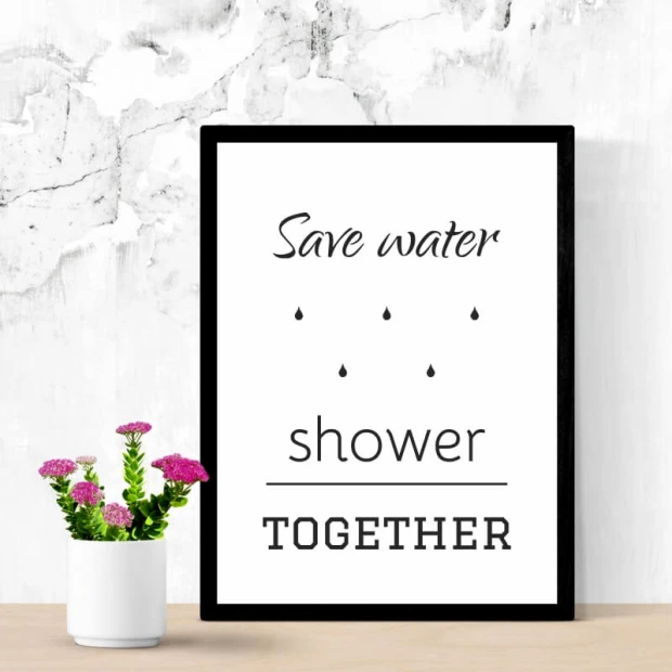 Plakat typograficzny z angielskim napisem Save water shower together w czarnej ramie zaprezentowany we wnętrzu