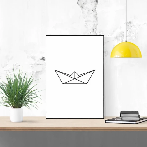 Plakat w czarnej ramie przedstawiający minimalistyczny rysunek papierowego statku na białym tle