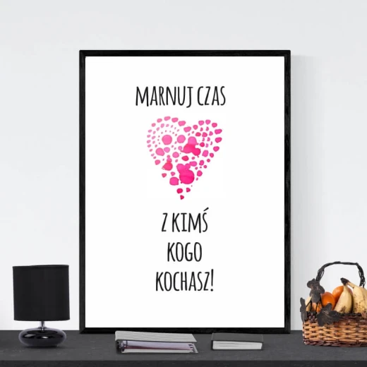 Plakat w czarnej ramie z napisem Marnuj czas z kimś kogo kochasz i różowym sercem z kropek