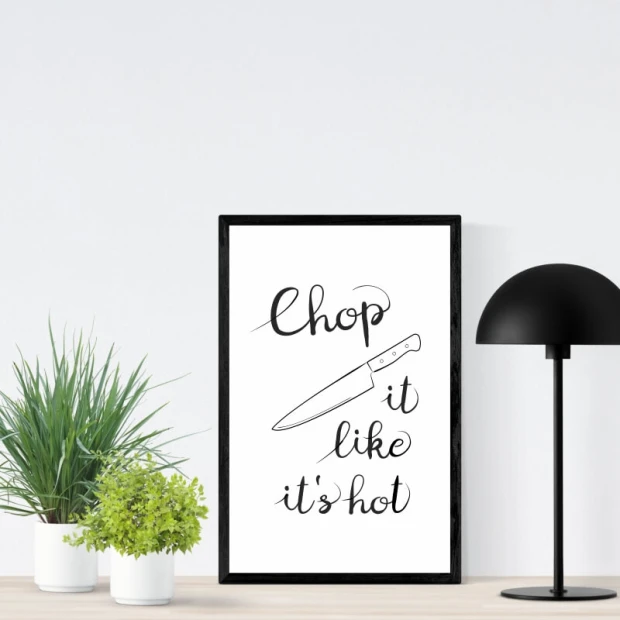 Plakat do kuchni w czarnej ramie z napisem Chop it like it\'s hot oraz rysunkiem noża kuchennego