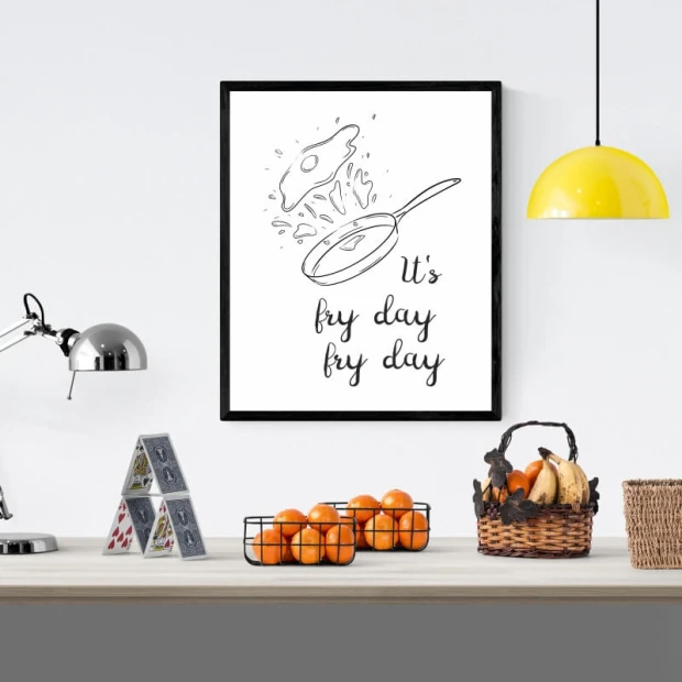 Plakat kuchenny w czarnej ramie z rysunkiem patelni i napisem It\'s fry day fry day na białym tle