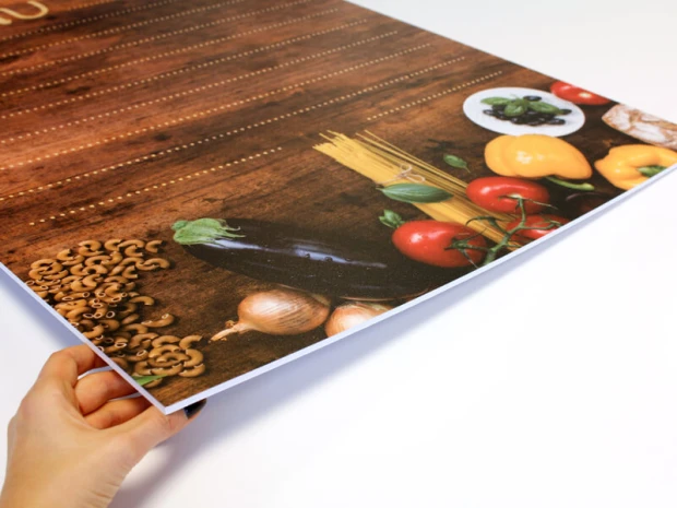 Tablica kredowa z nadrukiem menu i grafiką warzyw w ujęciu pokazującym grubość płyty i biały rdzeń