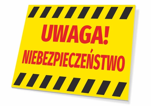 Żółta tabliczka ostrzegawcza BHP na białym tle z czerwonym napisem UWAGA! NIEBEZPIECZEŃSTWO i czarnymi pasami