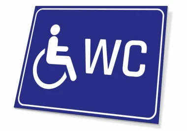 Tabliczka WC dla osób niepełnosprawnych - Wzór graficzny. Niebieskie tło z białym piktogramem osoby na wózku i napisem WC
