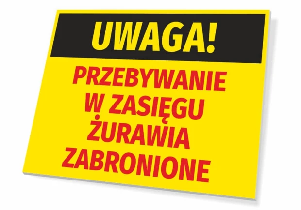 Żółta tabliczka ostrzegawcza BHP z napisem Uwaga! Przebywanie w zasięgu żurawia zabronione na białym tle