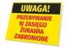 Tabliczka Uwaga Przebywanie w zasięgu żurawia zabronione - Wzór graficzny. Żółte tło z czarnym napisem na górze
