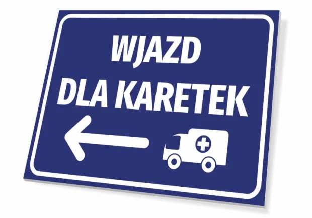 Niebieska tabliczka informacyjna z białym napisem Wjazd dla karetek, strzałką w lewo i piktogramem ambulansu