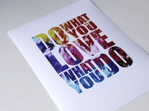 Plakat z motywacyjnym napisem Do what you love what you do pokazany z bliska pod kątem