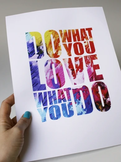 Plakat z kolorowym napisem Do what you love what you do trzymany w dłoni prezentuje rzeczywisty produkt