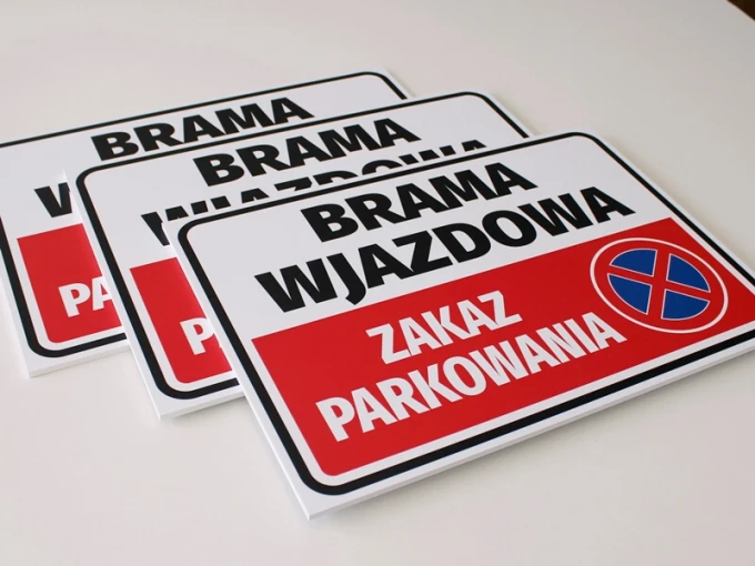 Tabliczka Brama wjazdowa, zakaz parkowania - Wzór graficzny. Prostokątna tabliczka z czerwonym tłem i białym napisem