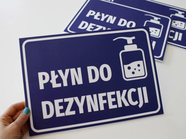 Tabliczka Płyn do dezynfekcji T415 - Wzór graficzny. Niebieskie tło z białym napisem i ikoną butelki