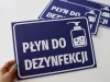 Tabliczka Płyn do dezynfekcji T415 - Wzór graficzny. Niebieskie tło z białym napisem i ikoną butelki