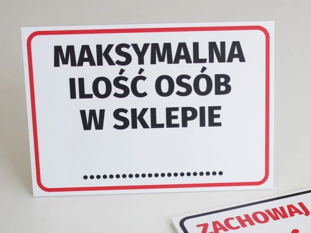 Tabliczka z napisem Maksymalna ilość osób w sklepie w ujęciu prezentującym grubość i sztywność płyty
