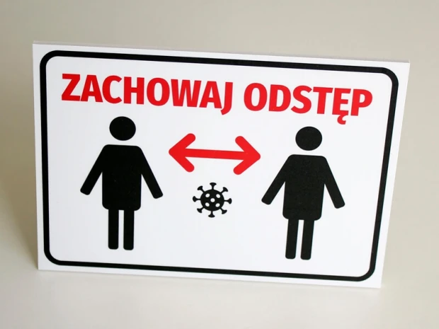 Tabliczka T413 Zachowaj odstęp - Wzór graficzny. Dwie postacie ludzkie z symbolem wirusa między nimi