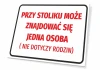 Tabliczka Przy stoliku może znajdować się jedna osoba - Wzór graficzny. Prosty prostokąt z czerwoną grafiką na białym tle