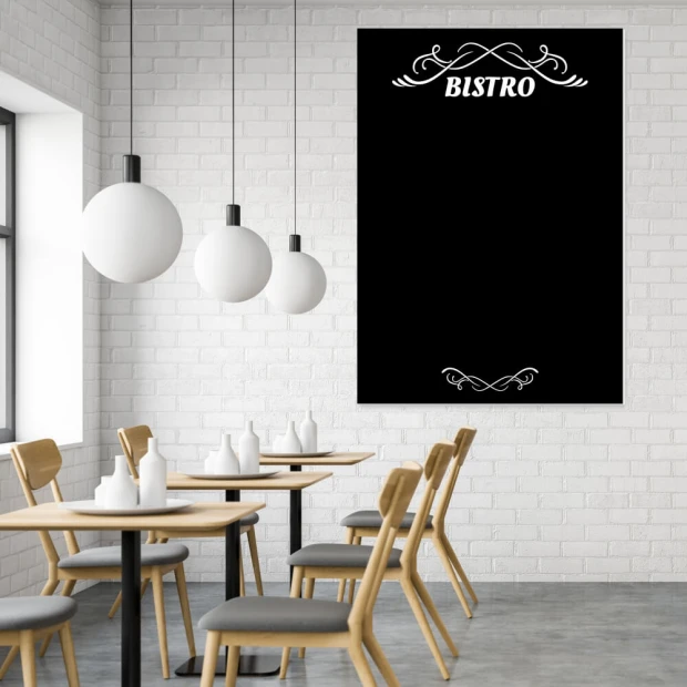 Tablica kredowa z nadrukiem napisu BISTRO i ozdobnych ornamentów we wnętrzu lokalu gastronomicznego