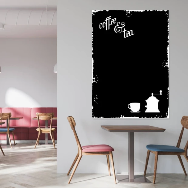 Czarna tablica kredowa z nadrukiem coffee and tea, filiżanką i młynkiem we wnętrzu kawiarni