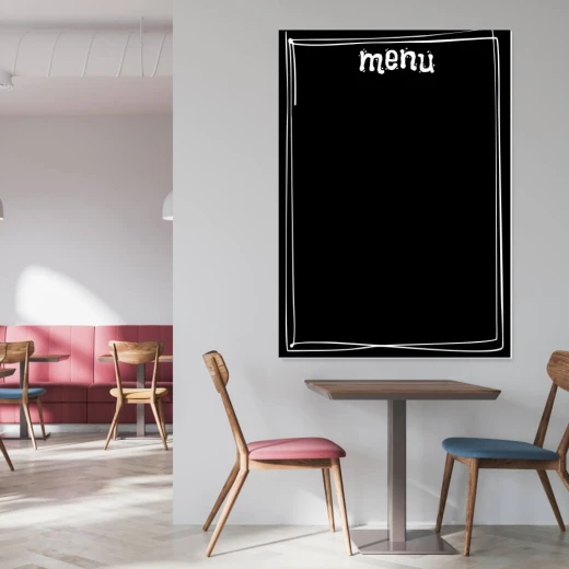 Tablica kredowa z nadrukiem menu i białą ramką we wnętrzu lokalu gastronomicznego