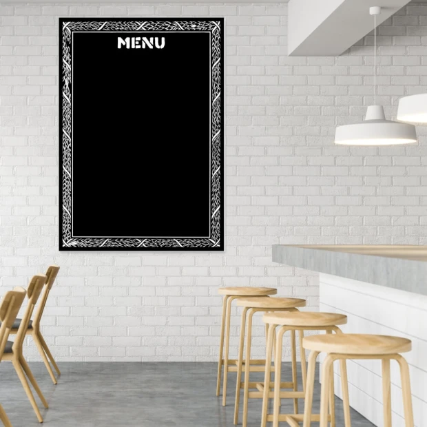 Tablica kredowa z nadrukiem ozdobnej ramki i napisem MENU we wnętrzu lokalu gastronomicznego