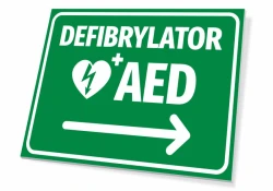 Tabliczka Defibrylator AED T560 - Wzór graficzny. Zielone tło, białe napisy, symbol serca z błyskawicą, strzałka w prawo