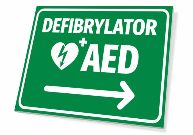 Tabliczka Defibrylator AED T560 - Wzór graficzny. Zielone tło, białe napisy, symbol serca z błyskawicą, strzałka w prawo