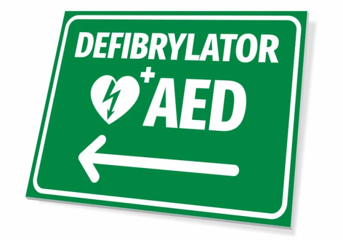 Tabliczka Defibrylator AED T561 - Wzór graficzny. Zielone tło z białym napisem i symbolem serca oraz strzałką w lewo