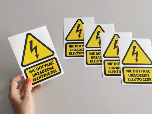 An image of a hand holding a yellow sticker.