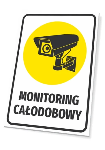 Tabliczka z napisem MONITORING CAŁODOBOWY oraz piktogramem kamery na żółtym tle, pokazana na białym tle