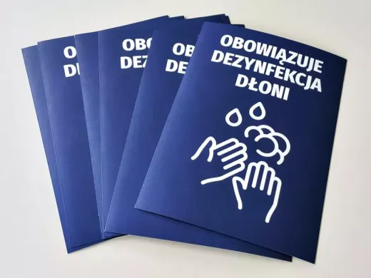 Niebieskie naklejki BHP z nakazem dezynfekcji dłoni i piktogramem rąk do biur, ułożone w wachlarz