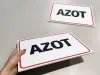 Tabliczka Azot - Wzór graficzny. Prosta tabliczka z napisem AZOT w dużych, czarnych literach na białym tle z czerwoną ramką