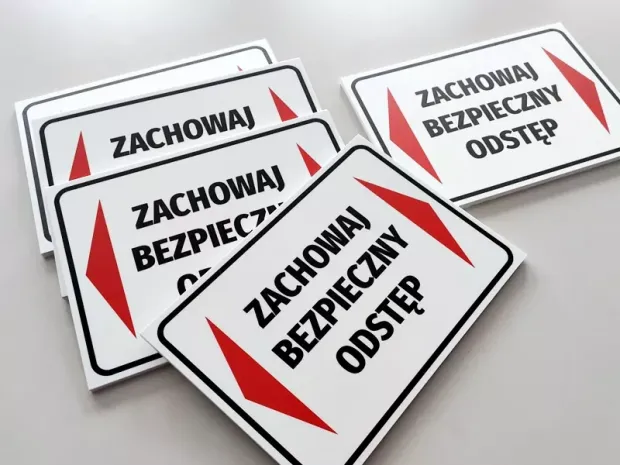 Tabliczka Zachowaj bezpieczny odstęp - Wzór graficzny. Prostokątna tabliczka z białym tłem, czerwonymi strzałkami i czarnym