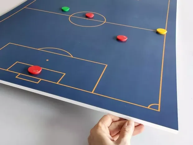 Tablica taktyczna z nadrukiem boiska, prezentująca grubość podkładu PCV oraz ułożone na niej magnesy