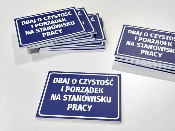 Tabliczka Dbaj o czystość i porządek na stanowisku pracy - Wzór graficzny. Prostokątna tabliczka z białym tekstem