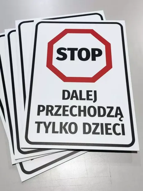 Tabliczka BHP Stop dalej przechodzą tylko dzieci leżąca w stosie kilku sztuk gotowego produktu